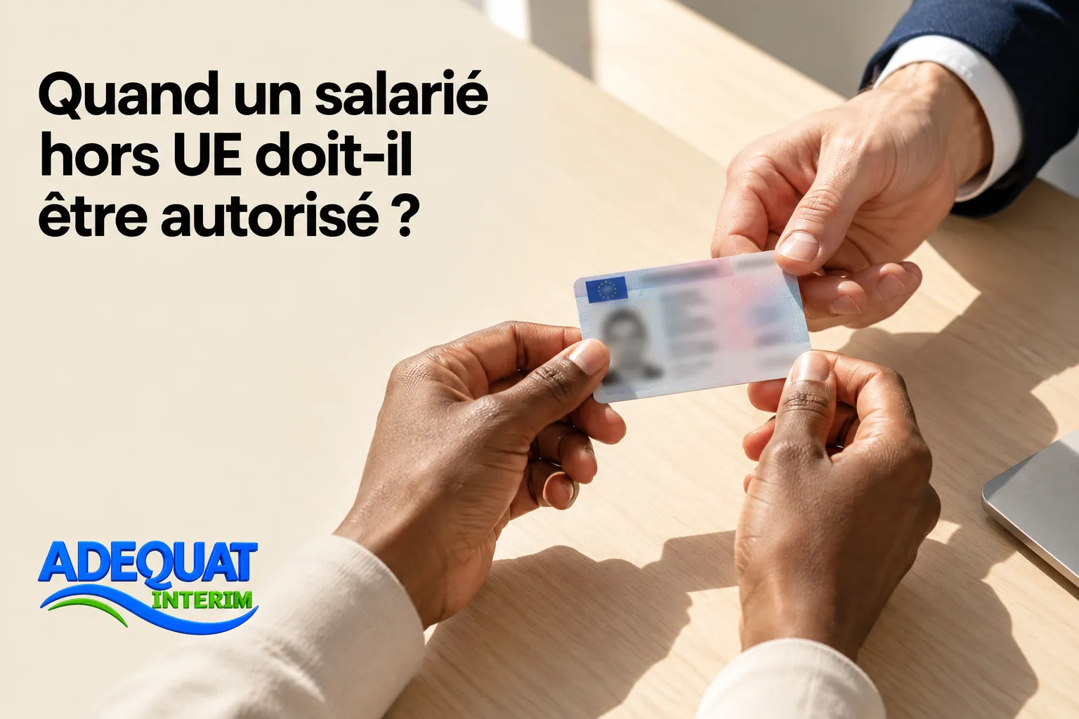 Deux mains se passent une carte d'identité ou de séjour sur une table.