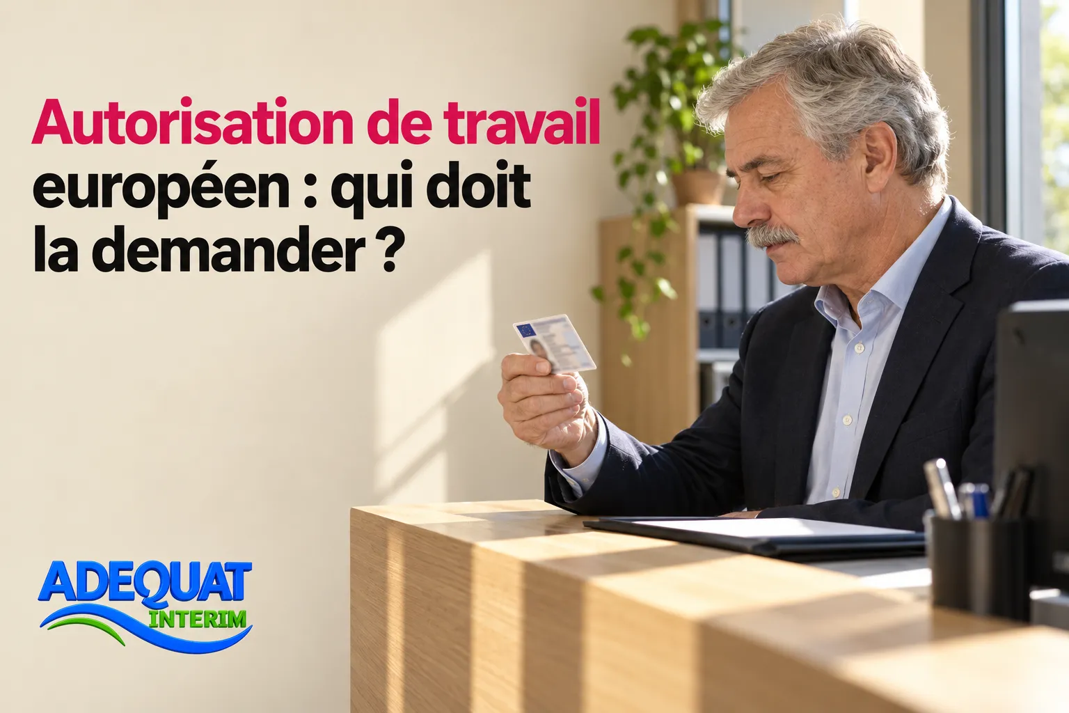 Un homme d’âge moyen tient une carte ou un document devant lui dans un bureau.